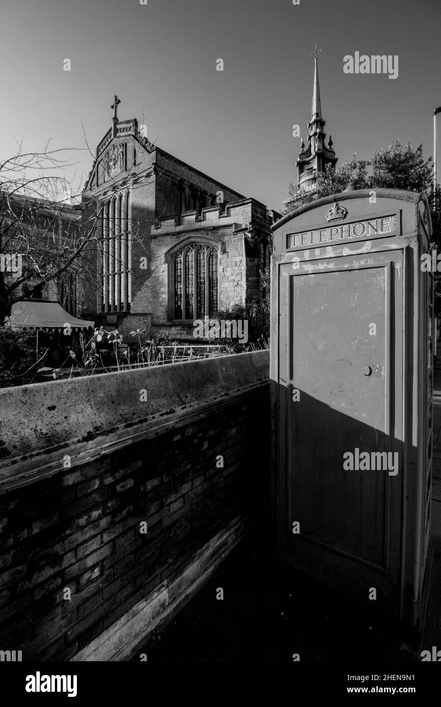 All Hallows-by-the-Tower, antica chiesa anglicana, Byward Street, City of London, Inghilterra, con cabina telefonica rossa in primo piano Foto Stock