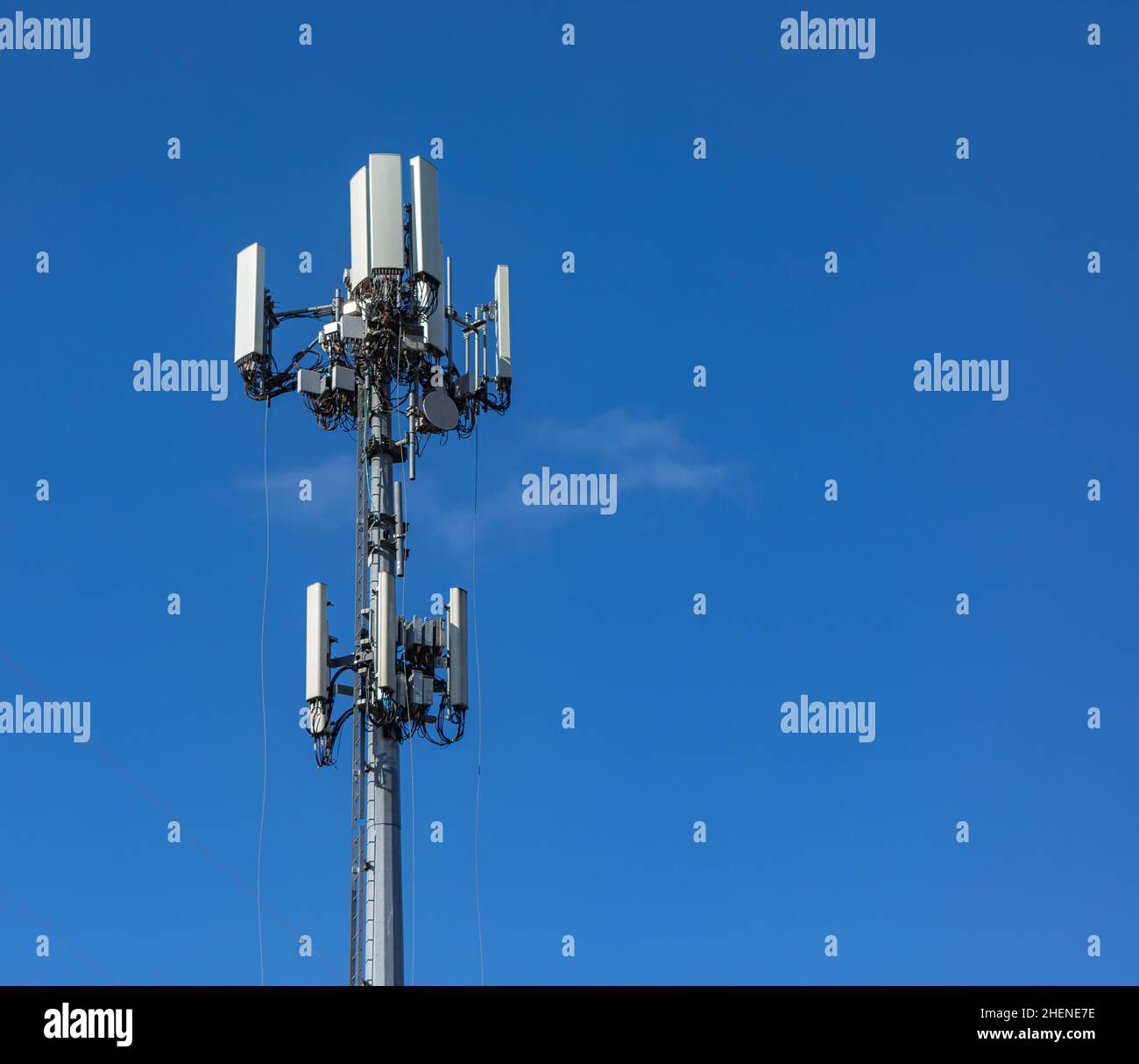 Torre per telecomunicazioni con 5G antenne di rete cellulare su sfondo cielo blu. Nessuno, spazio di copia per il testo, concetto di fotografia futura tecnologia. Foto Stock