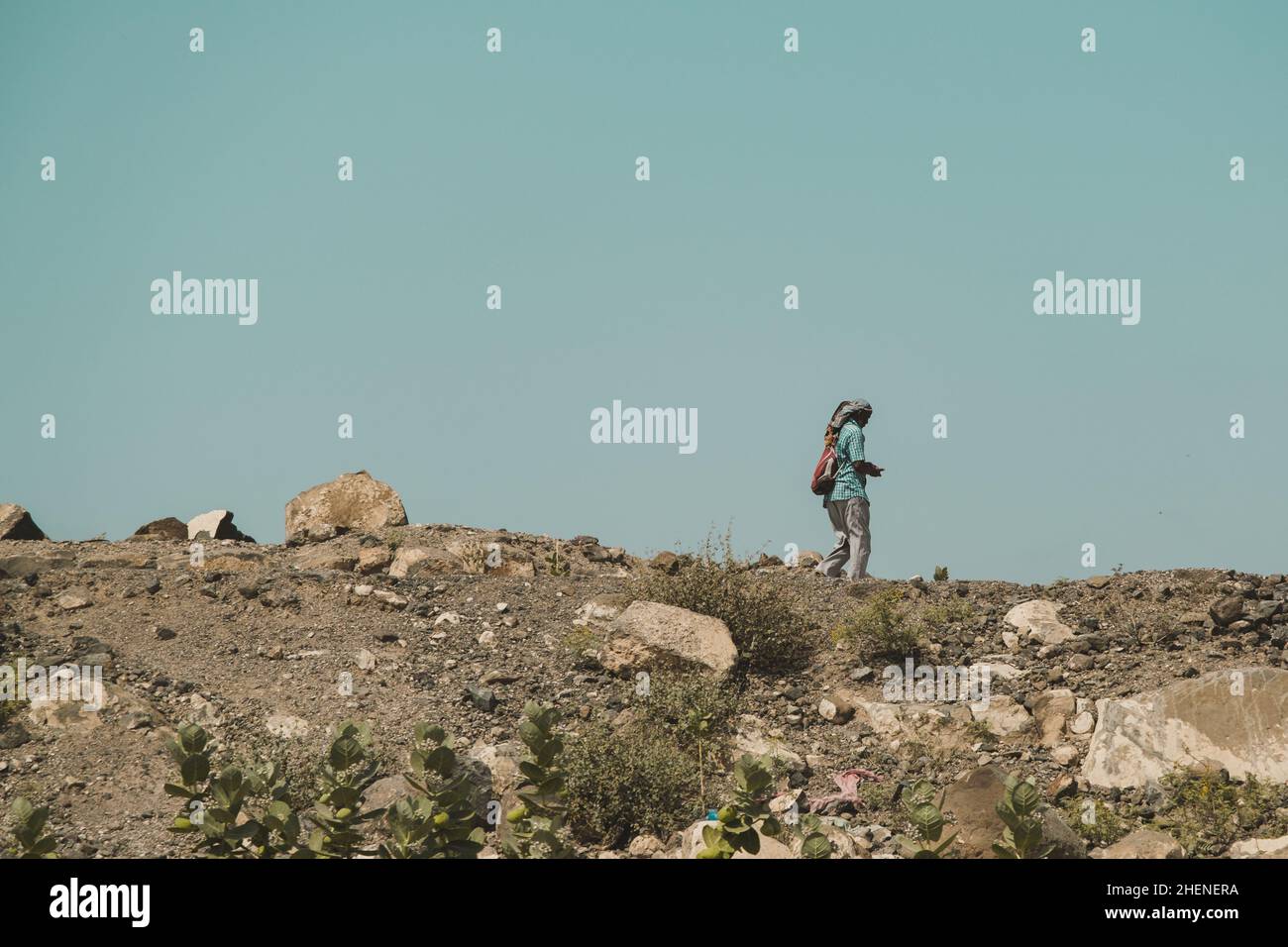 Gibuti, Gibuti - 21 maggio 2021: Un uomo solo Gibutiano che cammina nella terra arida. Scatto editoriale a Gibuti. Foto Stock