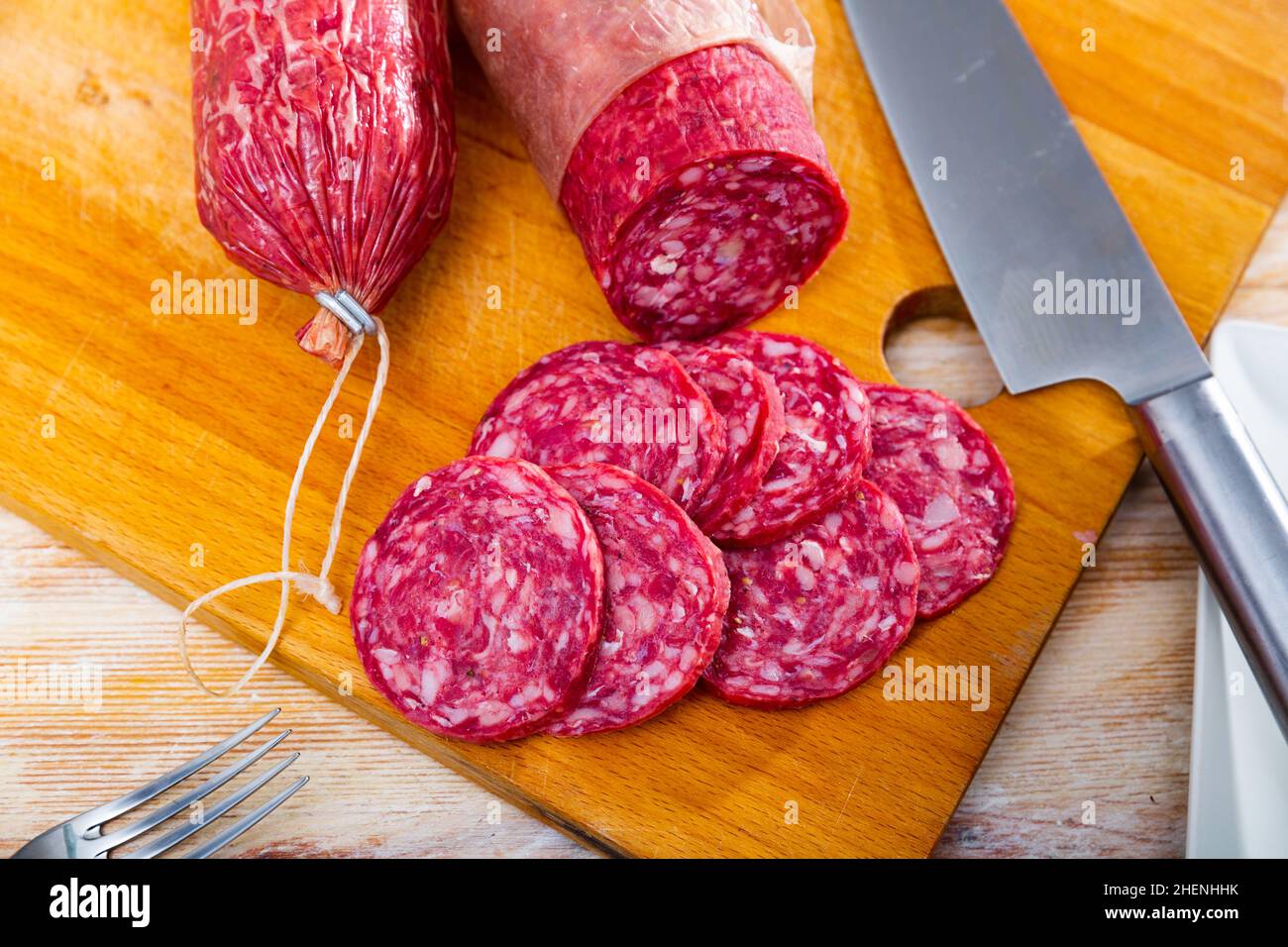 Salchichon di salsiccia di maiale salato a secco iberico su sfondo di legno Foto Stock