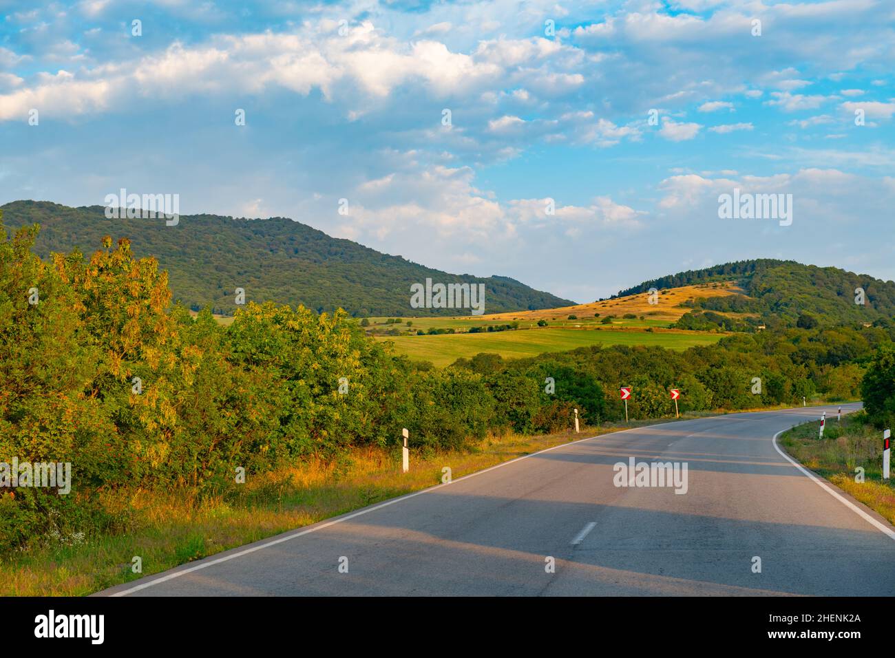 una stretta strada sterrata verso le montagne va Foto Stock