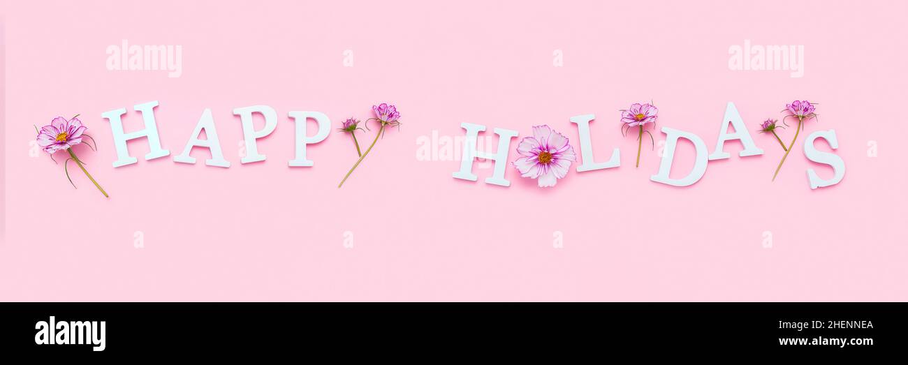 Buone vacanze. Banner con citazione motivazionale da lettere bianche e fiori naturali di bellezza su sfondo rosa. Concetto creativo citazione di ispirazione. Foto Stock