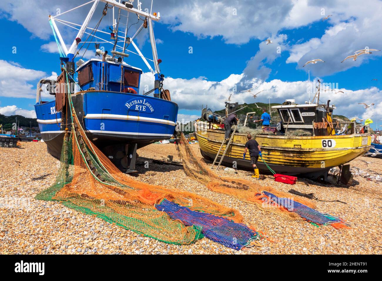 Barche da pesca, con reti che si asciugano, sulla spiaggia dei pescatori di Hastings Stade Foto Stock