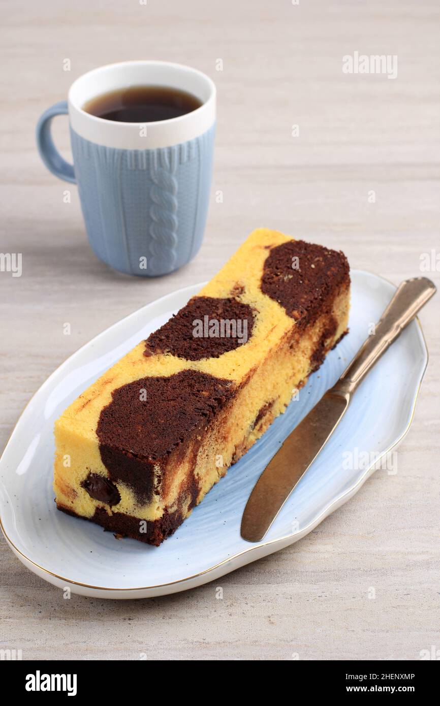 Torta di viaggio, mini torta di marmo a pagnotta con cioccolato fuso all'interno. Noto anche come torta a tubo. Servito con tè Foto Stock