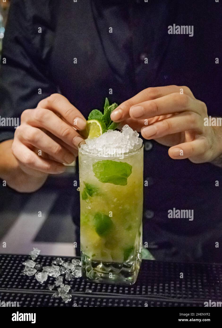 un barista che fa un rinfrescante cocktail mojito in un nightclub della costa del sol Foto Stock