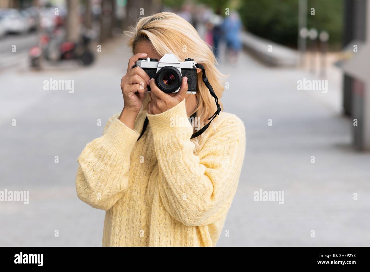 Donna che scatta una foto per strada Foto Stock
