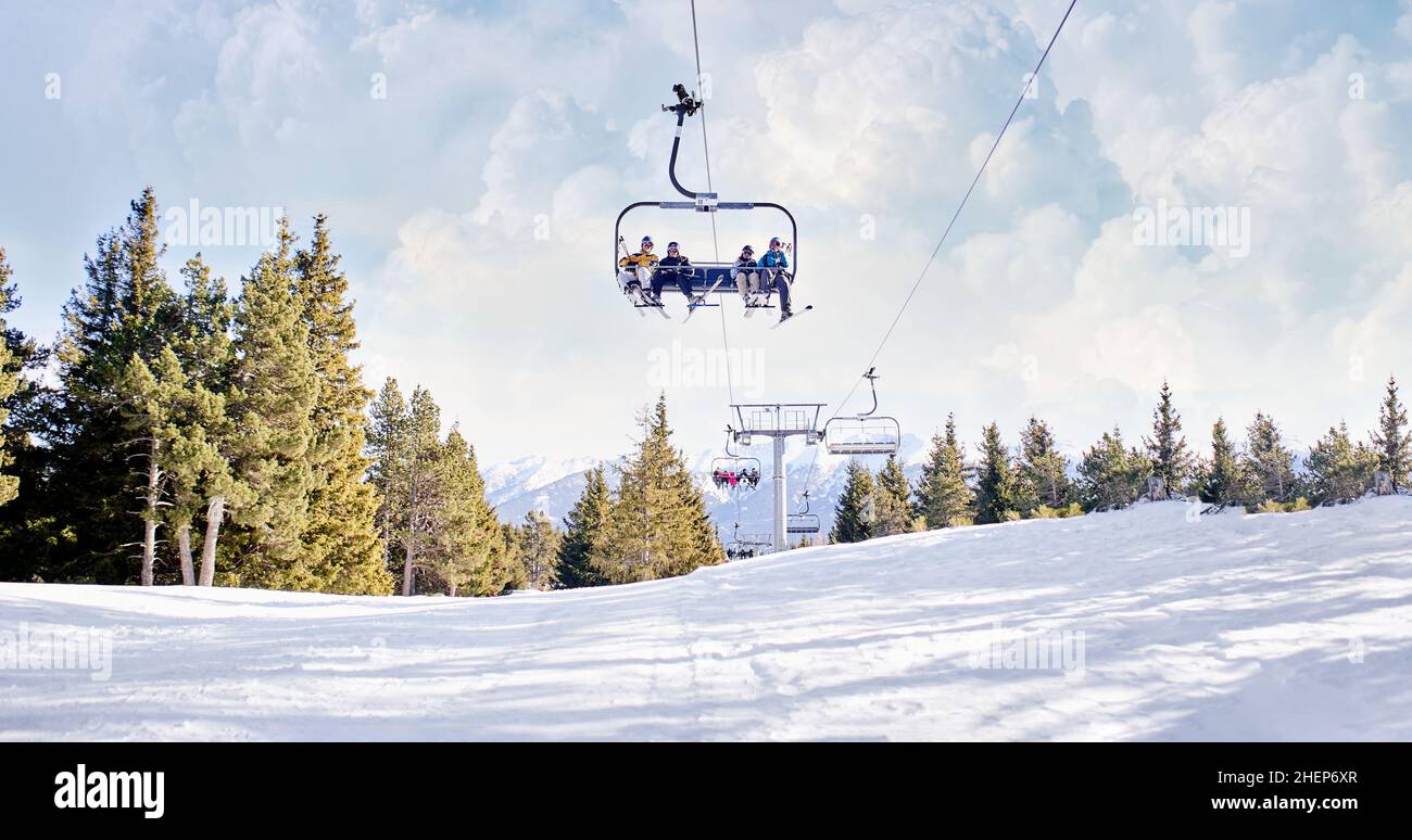 Gruppo di sciatori che si divertono sugli impianti di risalita della località sciistica. Panorama invernale delle montagne con piste da sci e seggiovia. Foto Stock