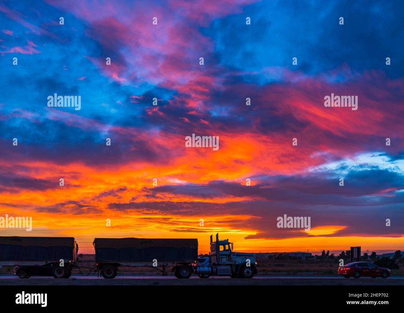 camion sulla strada con il tramonto colorato cielo nuvoloso. Foto Stock