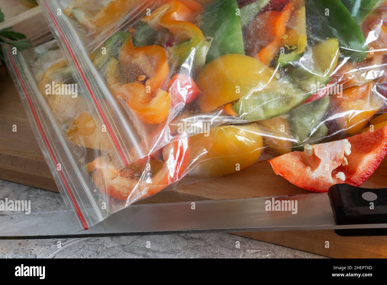 Affettato frutti maturi di peperone in sacchetti di cellophane, preparati per il congelamento e la conservazione a lungo termine nel comparto freezer del frigorifero. V. Anteriore Foto Stock