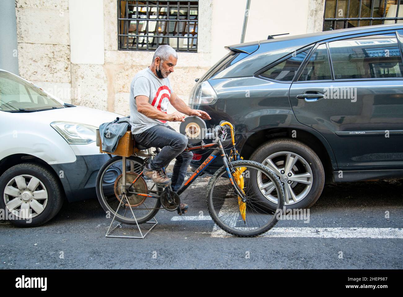 Un macinacaffè a coltello lavoro su una bicicletta a Chiado nella città di Lisbona in Portogallo. Portogallo, Lisbona, ottobre 2021 Foto Stock