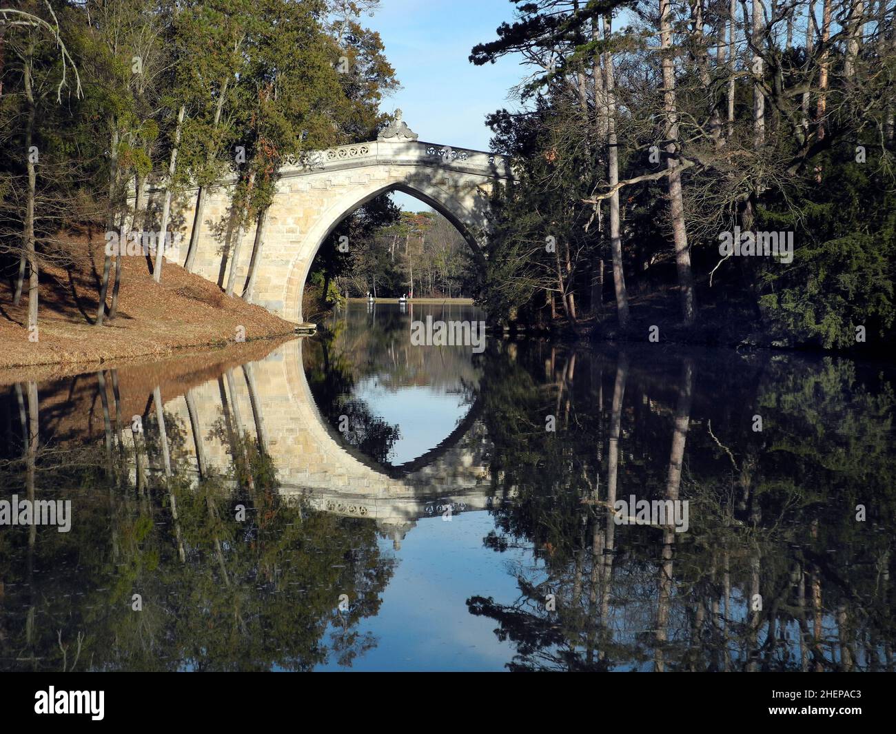 Austria, riflesso del ponte gotico nello stagno castello del parco pubblico di Laxenburg Foto Stock