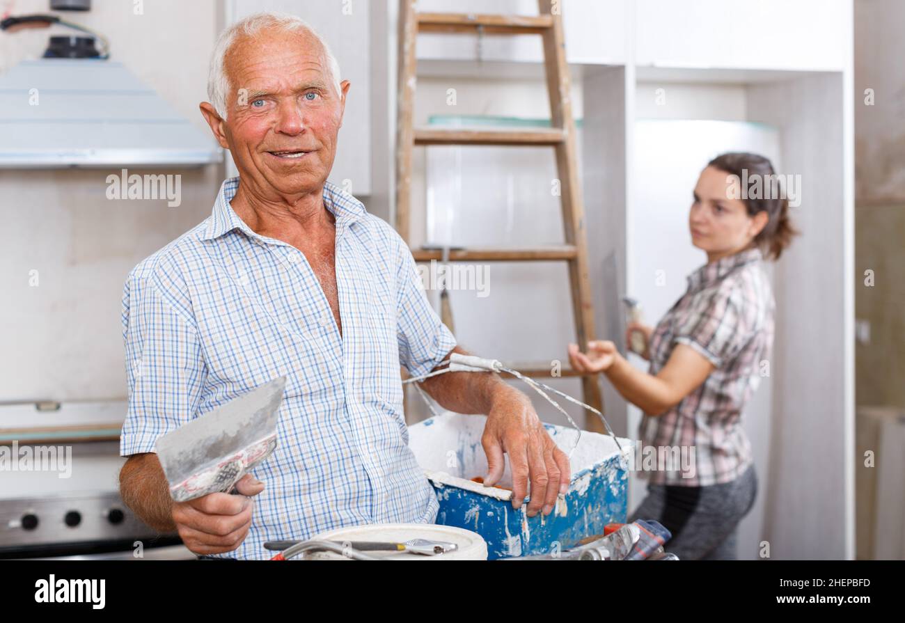 Muri mastice uomo anziano Foto Stock