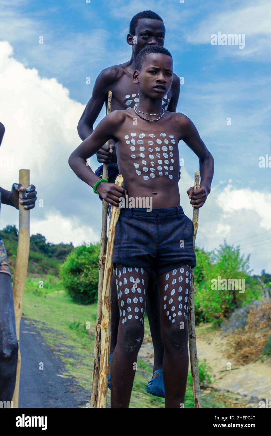 Primi piani ritratti di Benna Tribe Young Boys con Body Painting tradizionale sui Long Wooden Sticks Foto Stock