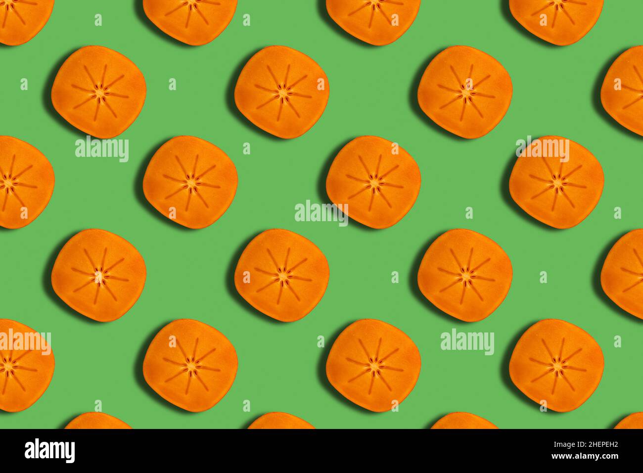 Pattern di fette di persimmon arancione mature su sfondo verde. Ripetizione senza giunture Foto Stock