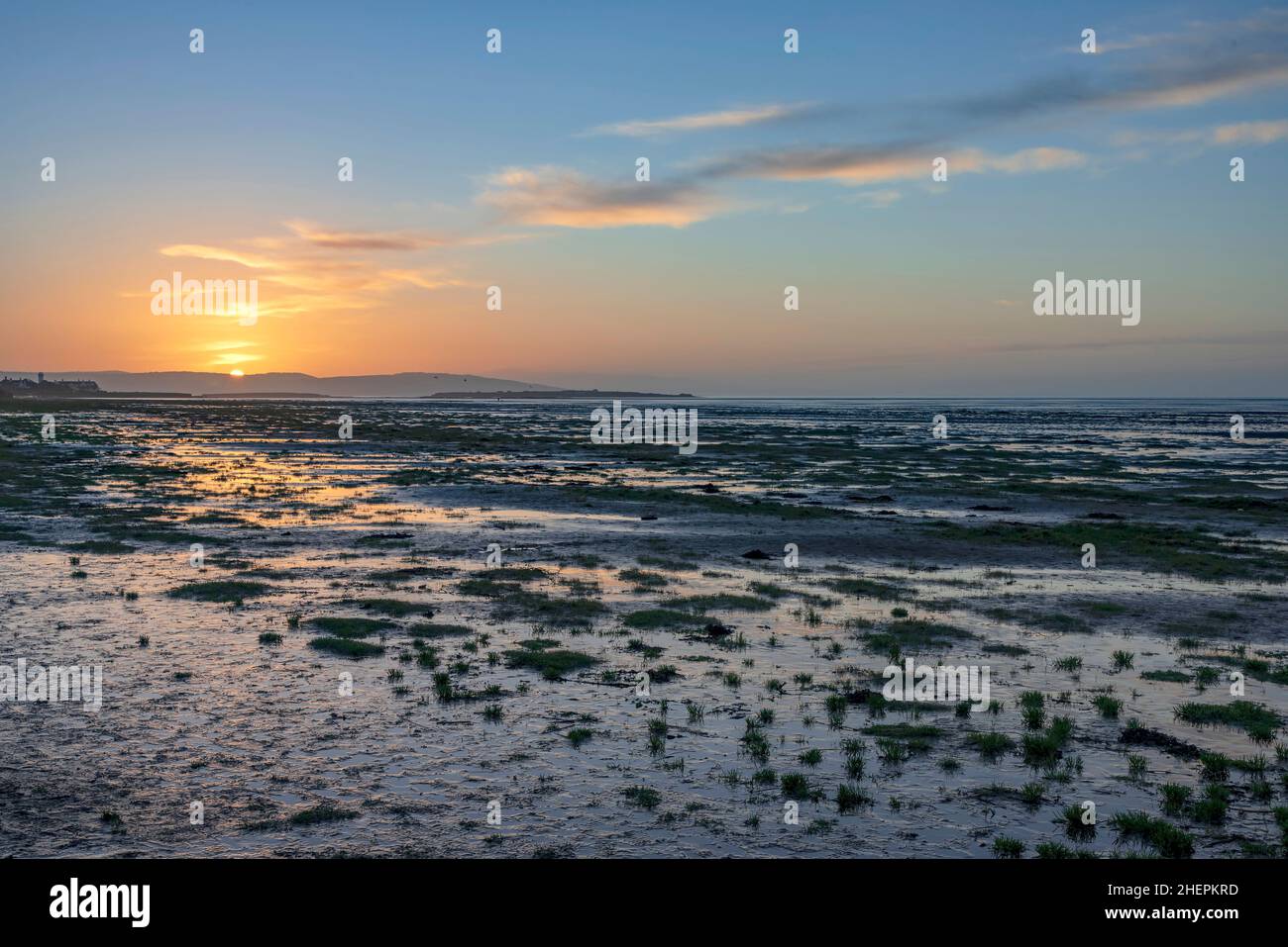 Tramonto sulla spiaggia di Hoylake sul fiume Dee estauary guardando al Galles sopra Hilbre Island. Foto Stock