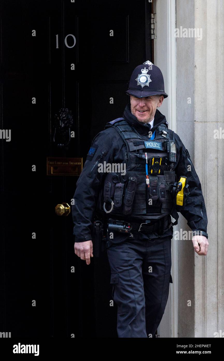 Londra, Regno Unito. 12 gennaio 2022. Un ufficiale di polizia è visto alla porta del numero 10 Downing Street davanti a Boris Johnson, primo Ministro in partenza per le domande del primo Ministro (PMQ) alla Camera dei Comuni. Il primo Ministro è sotto pressione da parte dei deputati per rispondere alle domande relative ad un partito il 20 maggio 2020 nei giardini di Downing Street 10, in un momento in cui le restrizioni di blocco del Regno Unito vietano gli incontri sociali. Credit: Stephen Chung / Alamy Live News Foto Stock