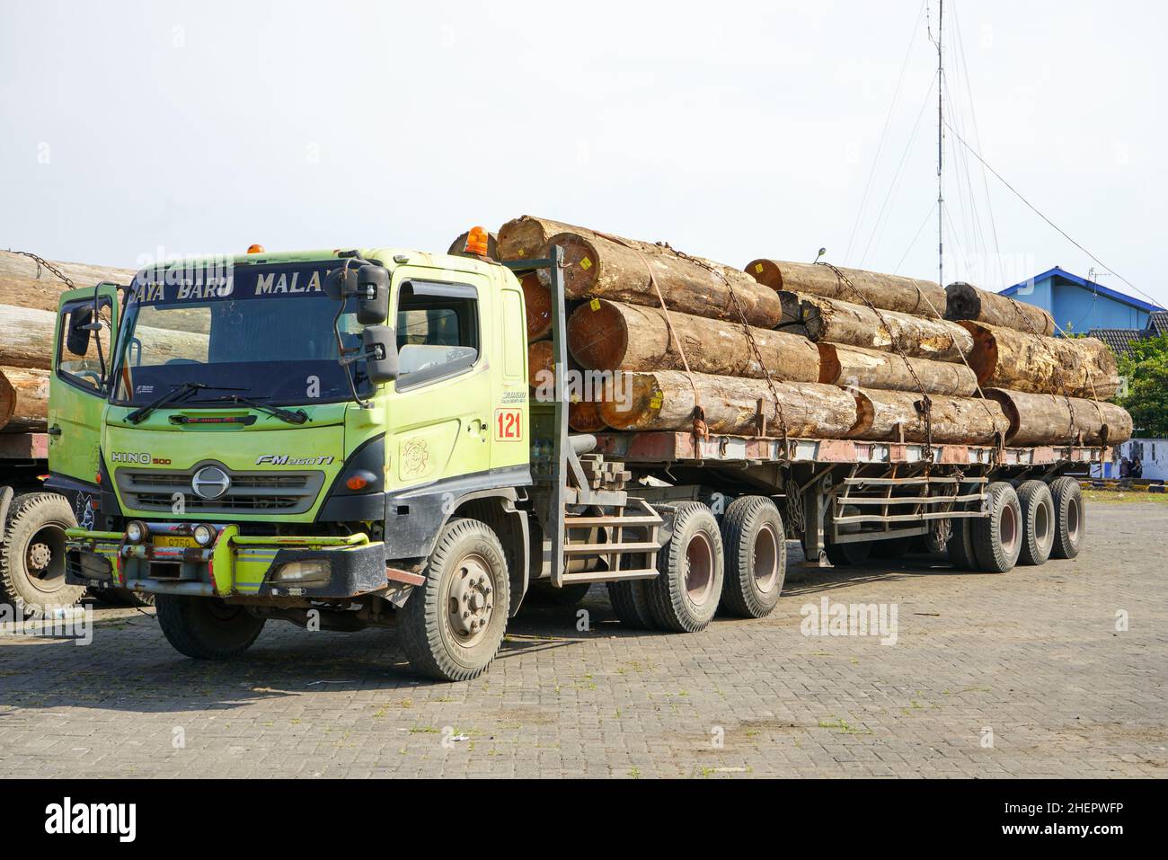 Pati, Indonesia - ottobre 2023: Camion che trasportano pile di legno tagliate dalla foresta per essere inviate ad una fabbrica di mobili per la realizzazione Foto Stock