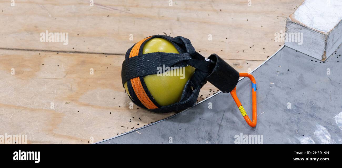 Un peso della scuola superiore utilizzato per l'evento di lancio del peso in pista e sul campo che poggia sul cerchio di lancio. Foto Stock
