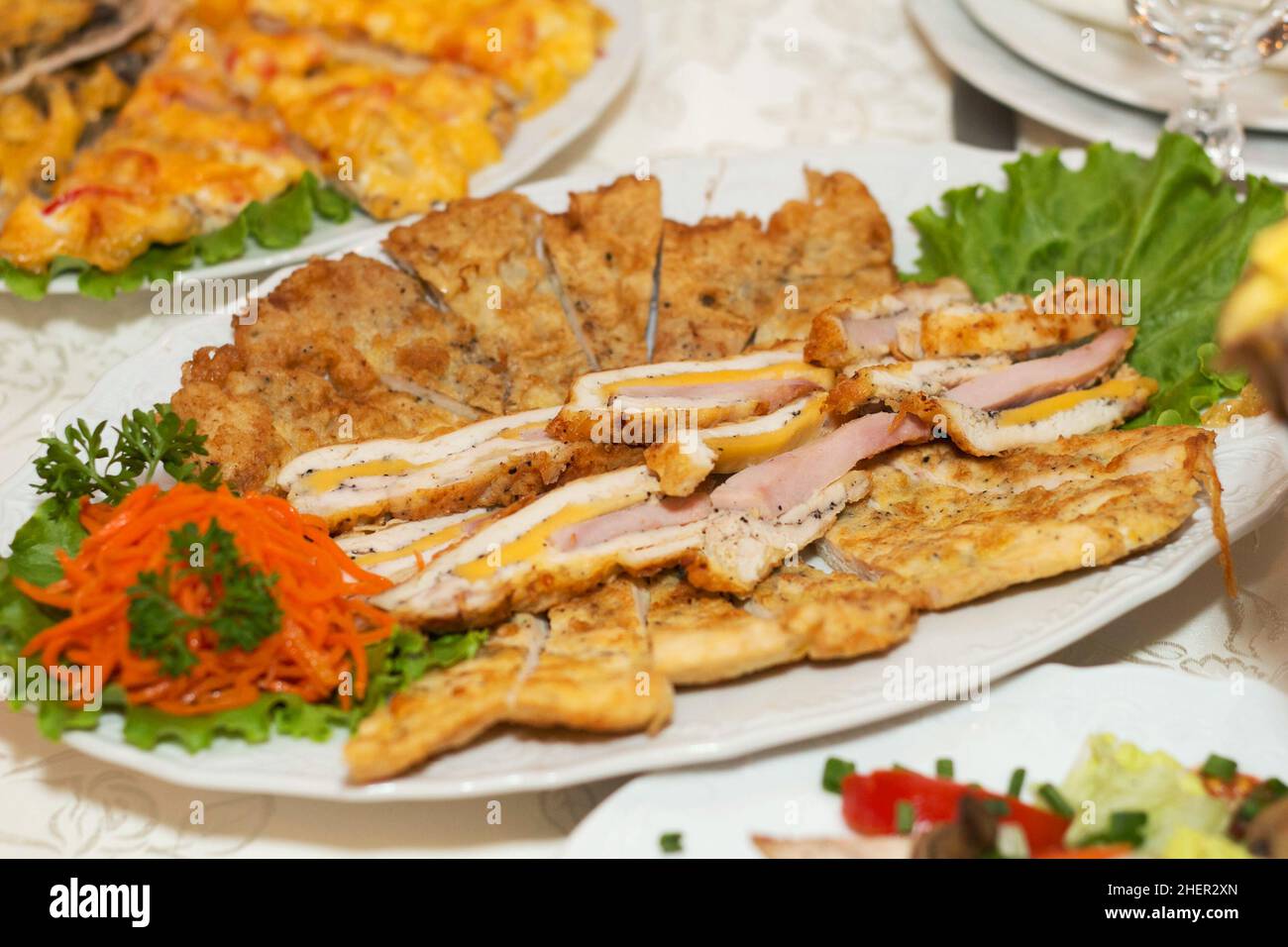 Antipasto di carne e fette di insalata su un piatto con foglie di lattuga Foto Stock