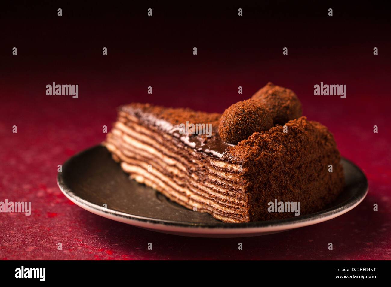 Torta al cioccolato multistrato Spartacus su sfondo borgogna Foto Stock