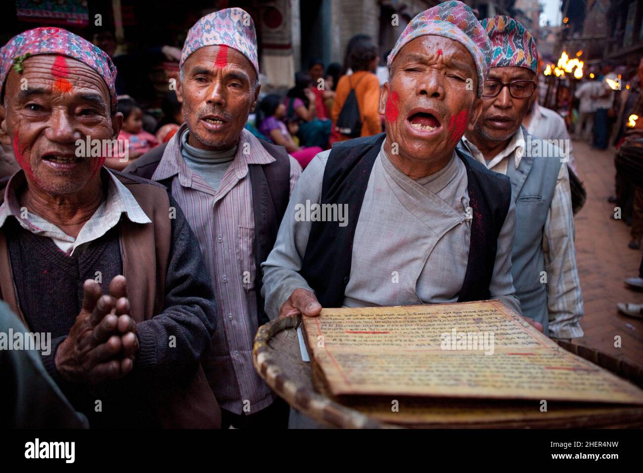 Uomini anziani che cantano da tombe ingiallite di Sanscrito durante Brahmayani Jatra in Piazza Dattatreya di Bhaktapur durante i festeggiamenti del nuovo anno nepalese. Foto Stock