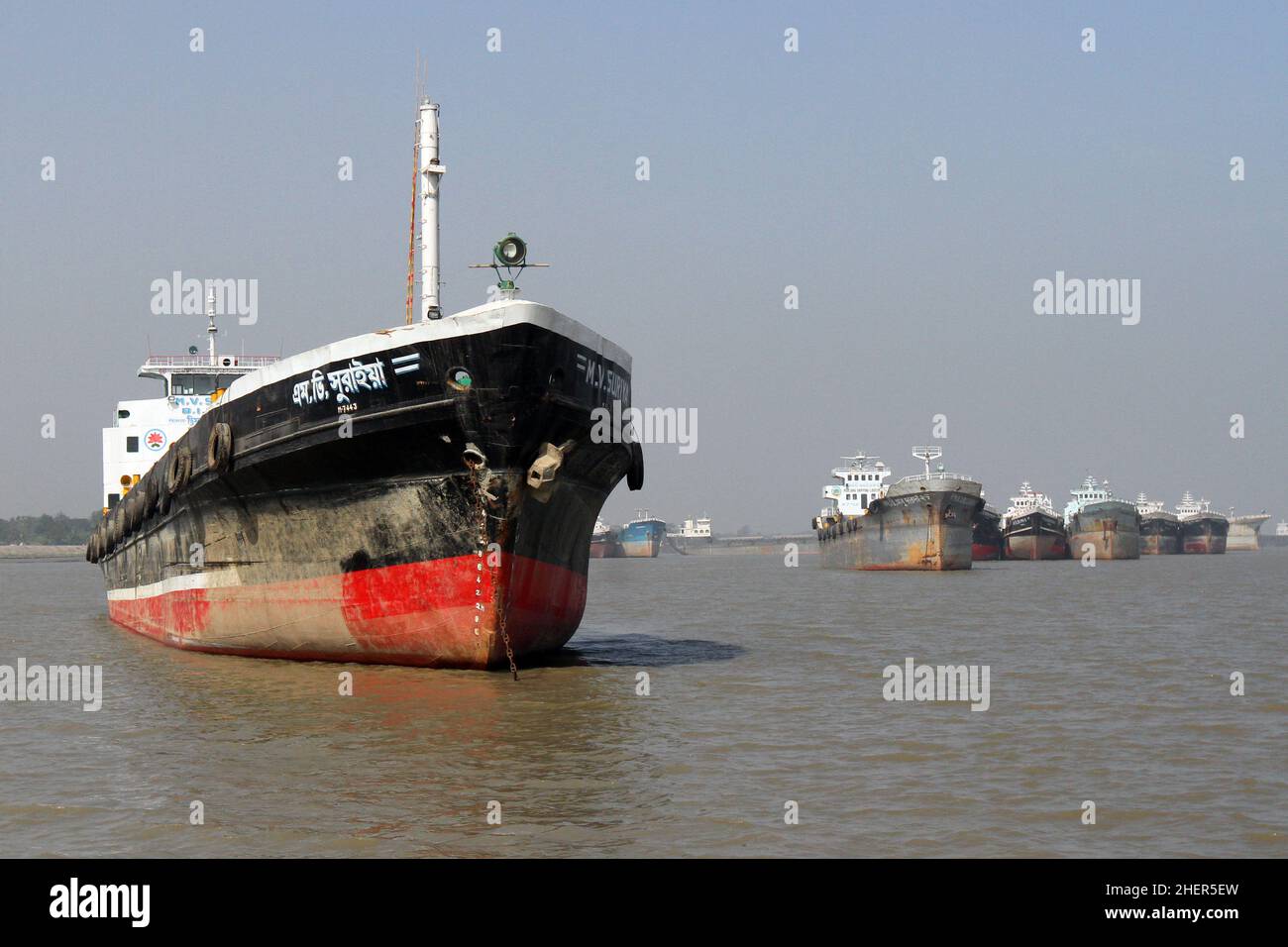 Bagerhat, Bangladesh - 11 gennaio 2015: Navi più leggere in attesa di carico e scarico di merci importate ed esportate nel fiume Pasur di fronte a Mon Foto Stock