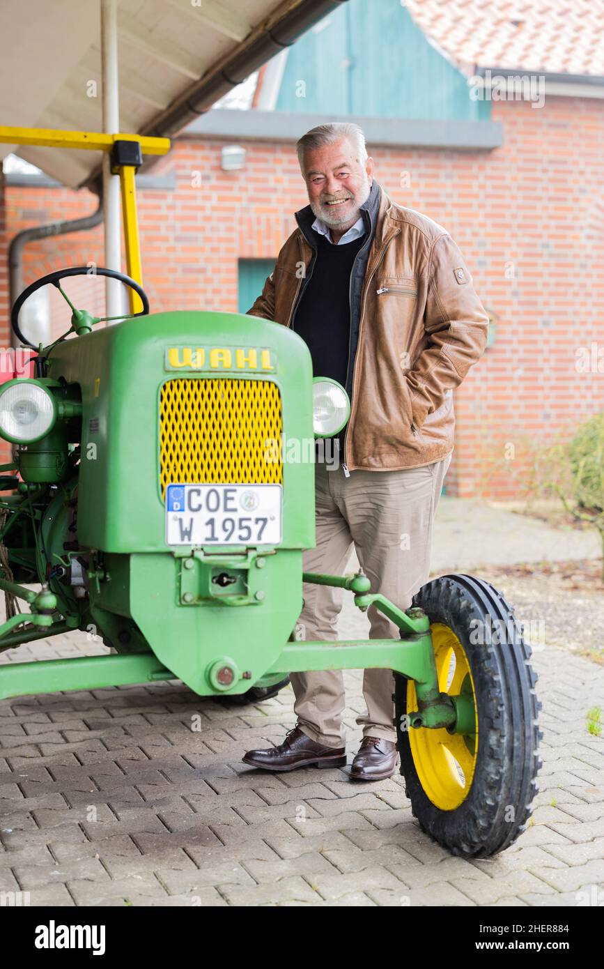 Senden, Germania. 12th Jan 2022. Harry Wijnvoord, presentatore olandese ('il prezzo è caldo'), si trova di fronte alla sua casa accanto al suo trattore storico (1957) del marchio Maschinenfabrik Carl Fr. Wahl. Credit: Rolf Vennenbernd/dpa/Alamy Live News Foto Stock