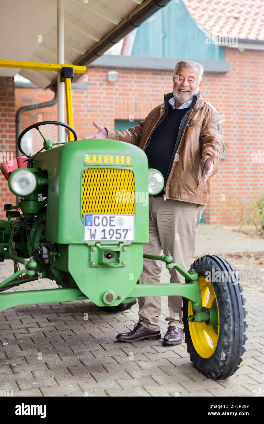 Senden, Germania. 12th Jan 2022. Harry Wijnvoord, presentatore olandese ('il prezzo è caldo'), si trova di fronte alla sua casa accanto al suo trattore storico (1957) del marchio Maschinenfabrik Carl Fr. Wahl. Credit: Rolf Vennenbernd/dpa/Alamy Live News Foto Stock