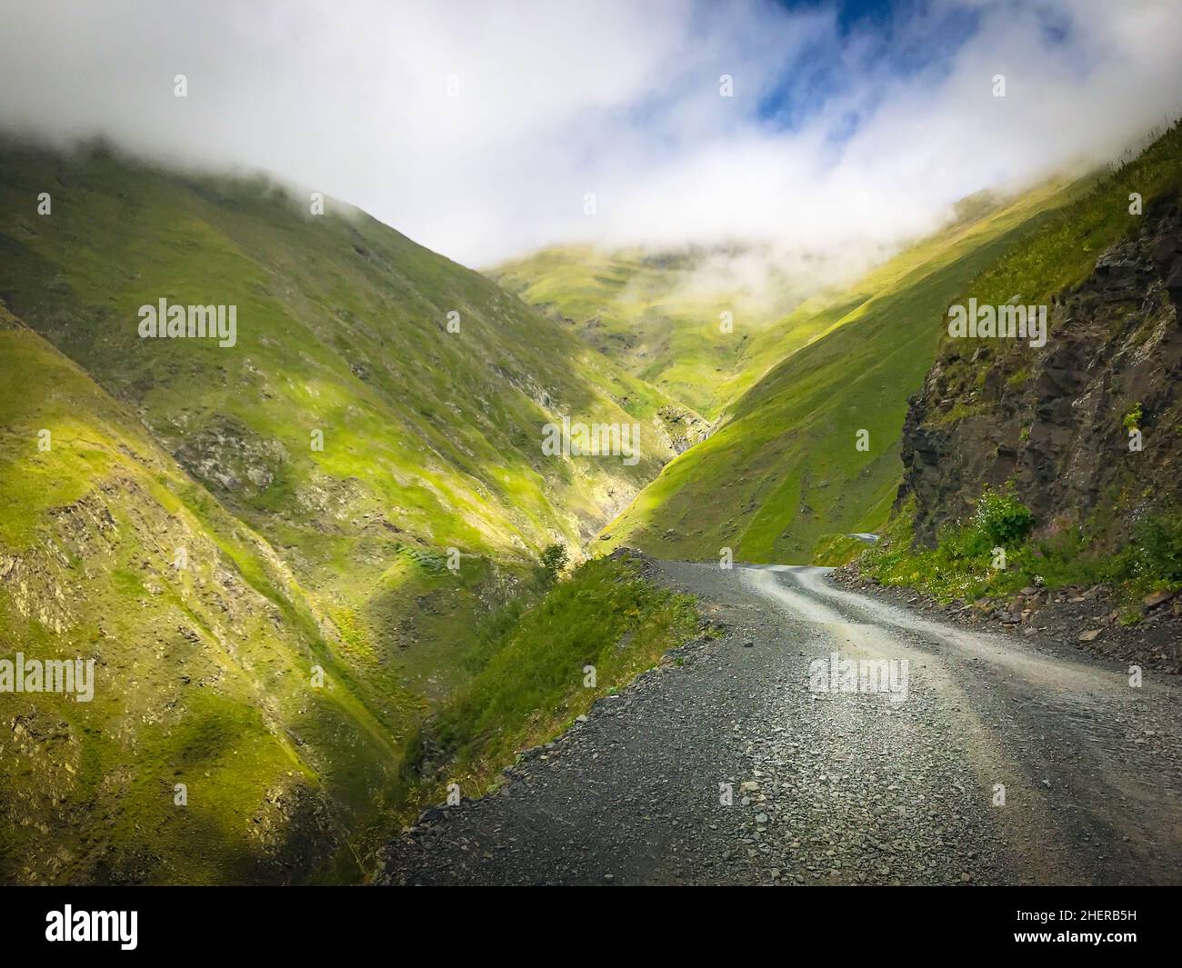 Strada panoramica in ghiaia di montagna nella regione di Tusheti circondata dalla natura nebbia del caucaso Foto Stock