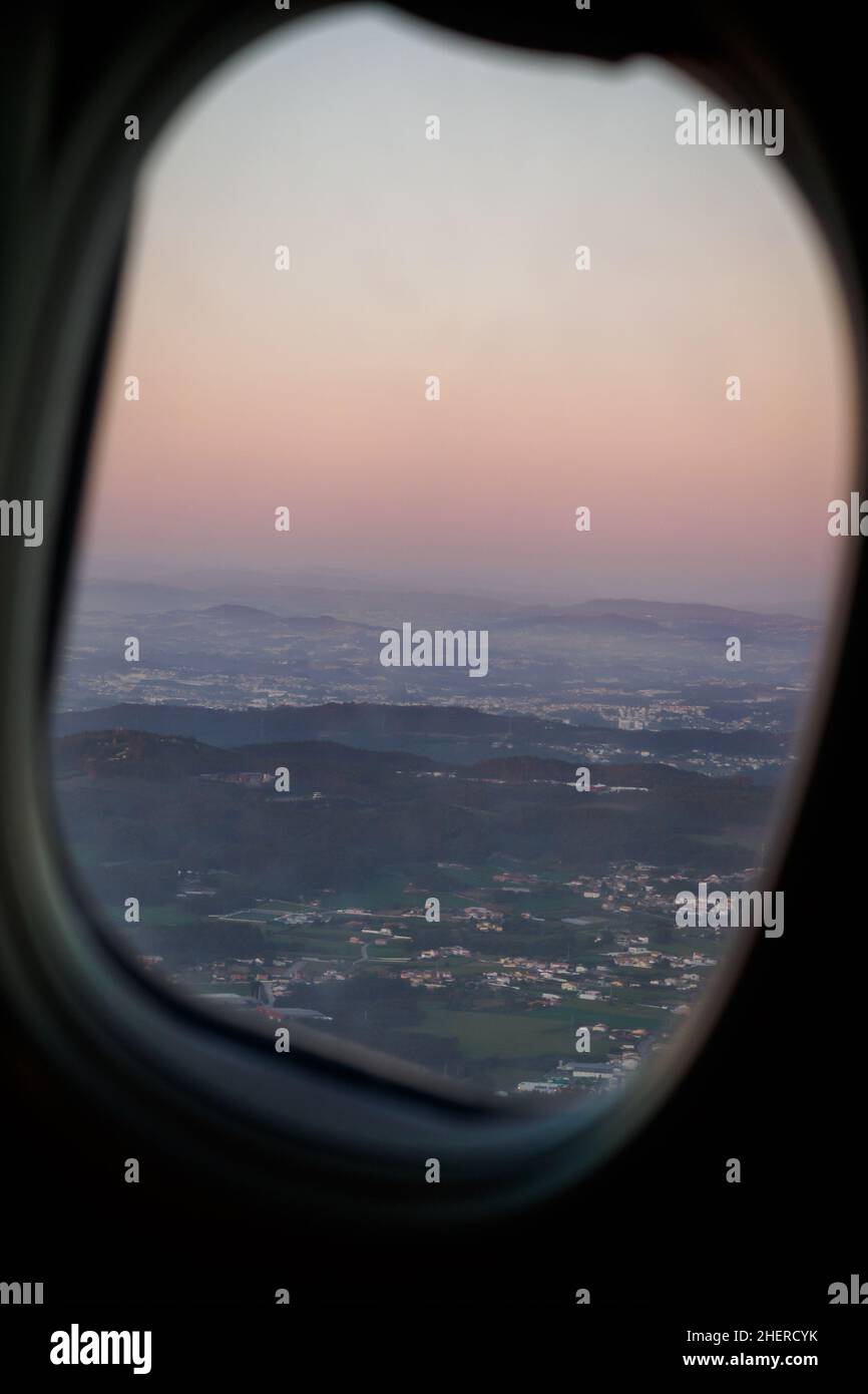 Vista della città di Porto al tramonto dalla finestra di un aereo durante il decollo, Portogallo Foto Stock