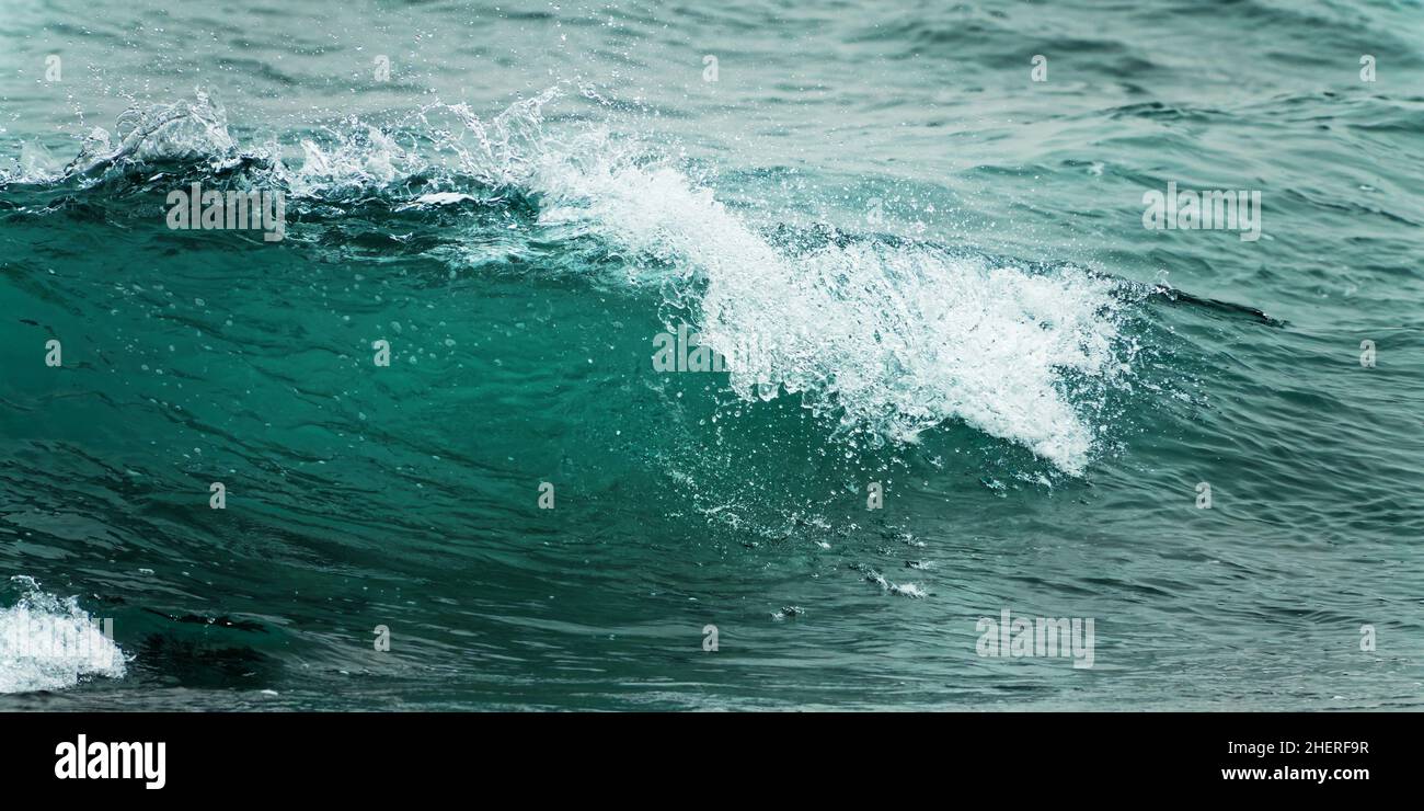 Primo piano di un'onda. Blu acqua limpida spruzzi, sfondo oceano. Foto Stock