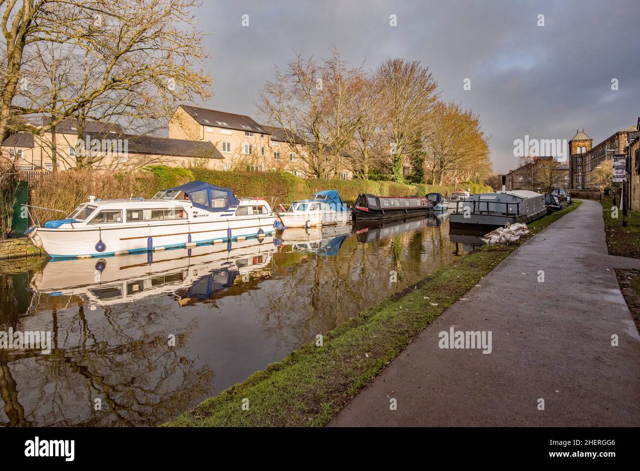 Skipton dove il canale Leeds Liverpool passa attraverso il canale Basin.Narrowboats ormeggiate qui vicino al Cotton Mill ex (ora appartamenti). Foto Stock