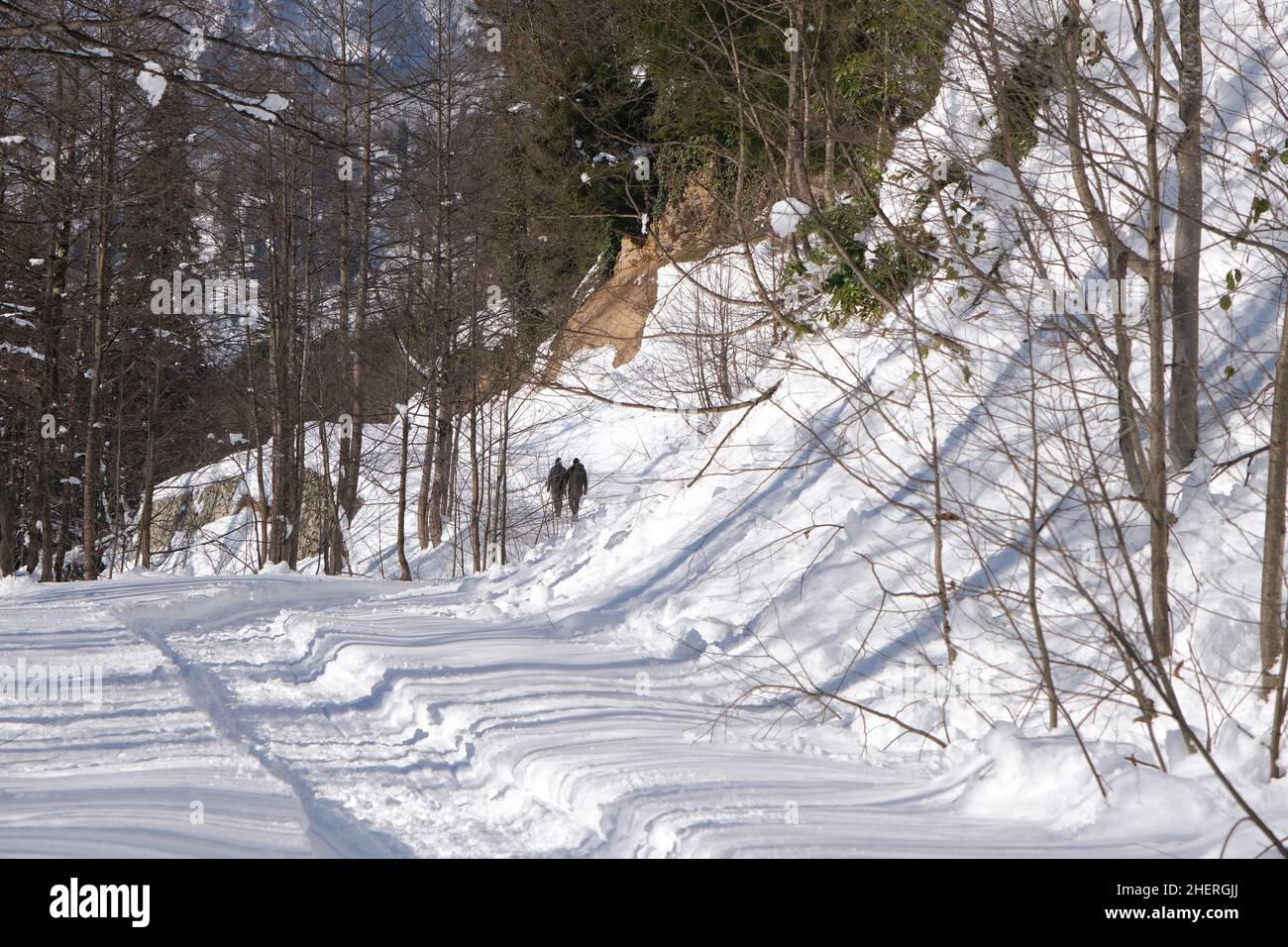 Sentiero strada sulla neve, due persone a piedi sulla neve in cima alla montagna. Trekking in inverno concetto idea Foto Stock