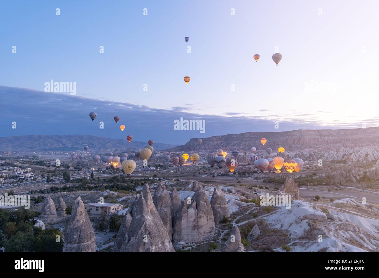 I palloncini ad aria calda volano sopra i camini delle fate all'alba in Cappadocia, Turchia. Volare su camini fairy con palloncini ad aria calda è l'attività migliore. Foto Stock
