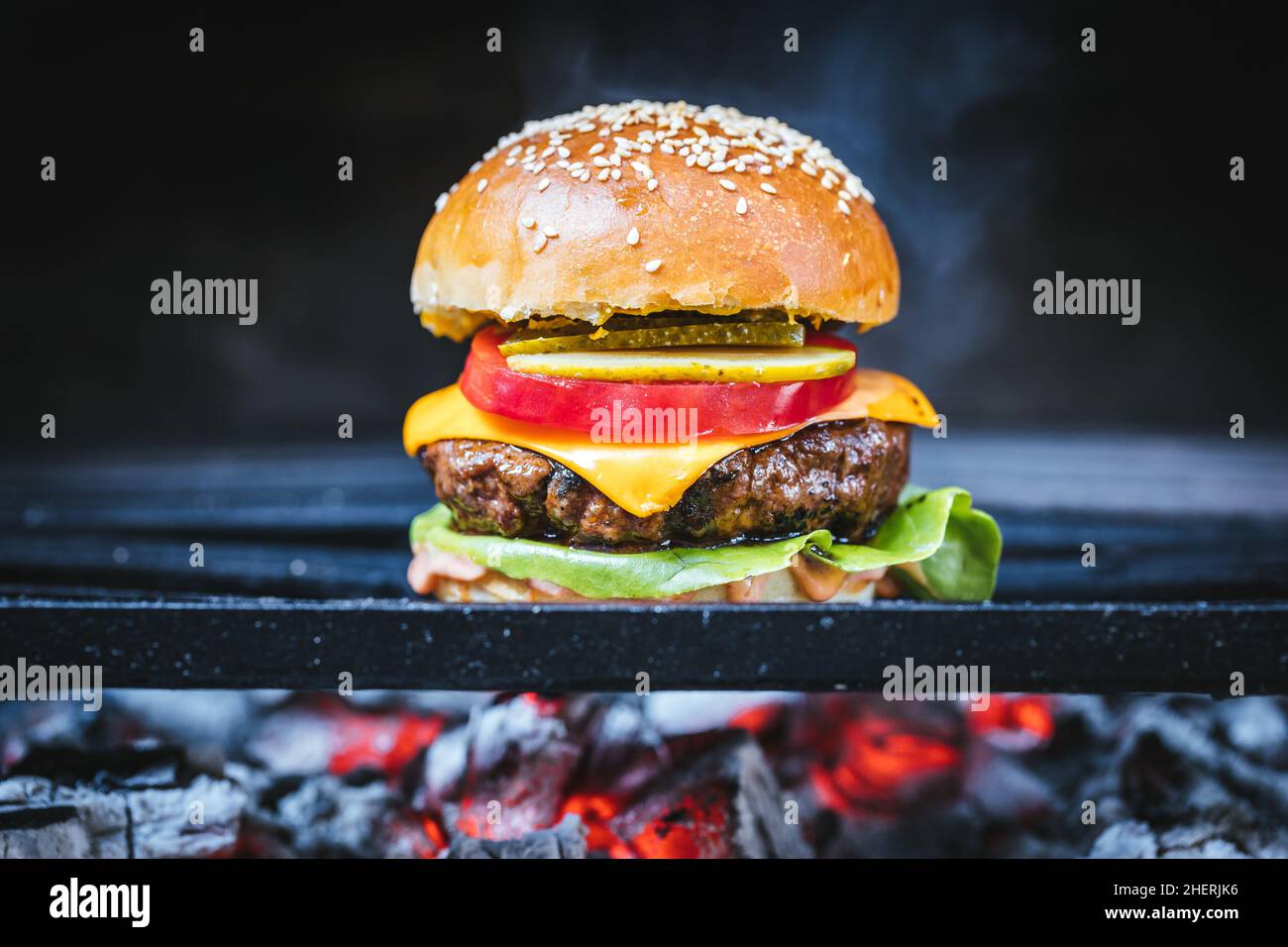 Burger classico e succosa preparato su una griglia barbecue a carbone. Fast food Foto Stock