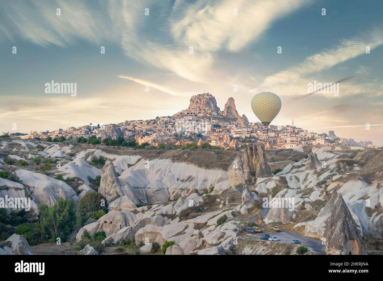 Castello di Uchisar, camini delle fate e mongolfiera che volano al tramonto in Cappadocia, Turchia. Antica città di Uchisar e camini delle fate. Foto Stock