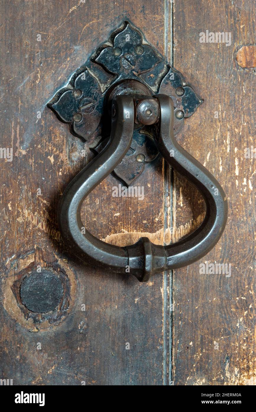 Maniglia per porta in metallo per impieghi pesanti su una vecchia porta in legno Foto Stock