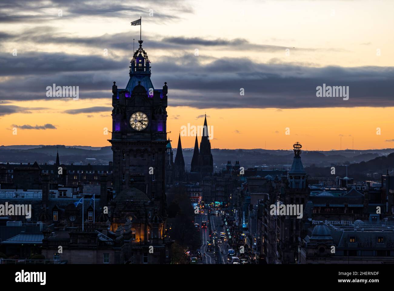 La torre dell'orologio Balmoral e Princes Street si illuminarono di notte con un tramonto colorato, Edimburgo, Scozia, Regno Unito Foto Stock