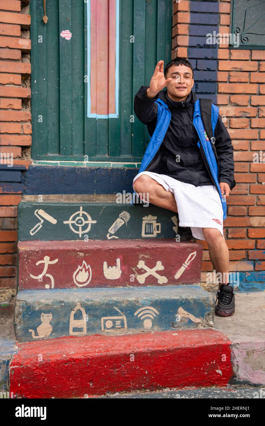 Giovane uomo seduto su gradini fuori da una casa nel famigerato quartiere Barrio Egipto, Bogota, Colombia, Sud America. Foto Stock