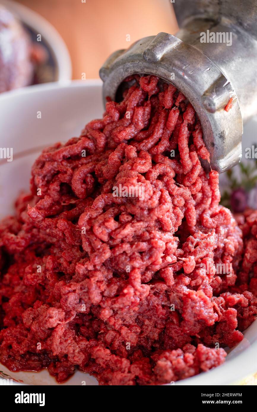 Carne di manzo macinata per cucinare hamburger macro. Carne macinata con macinacaffè vintage Foto Stock