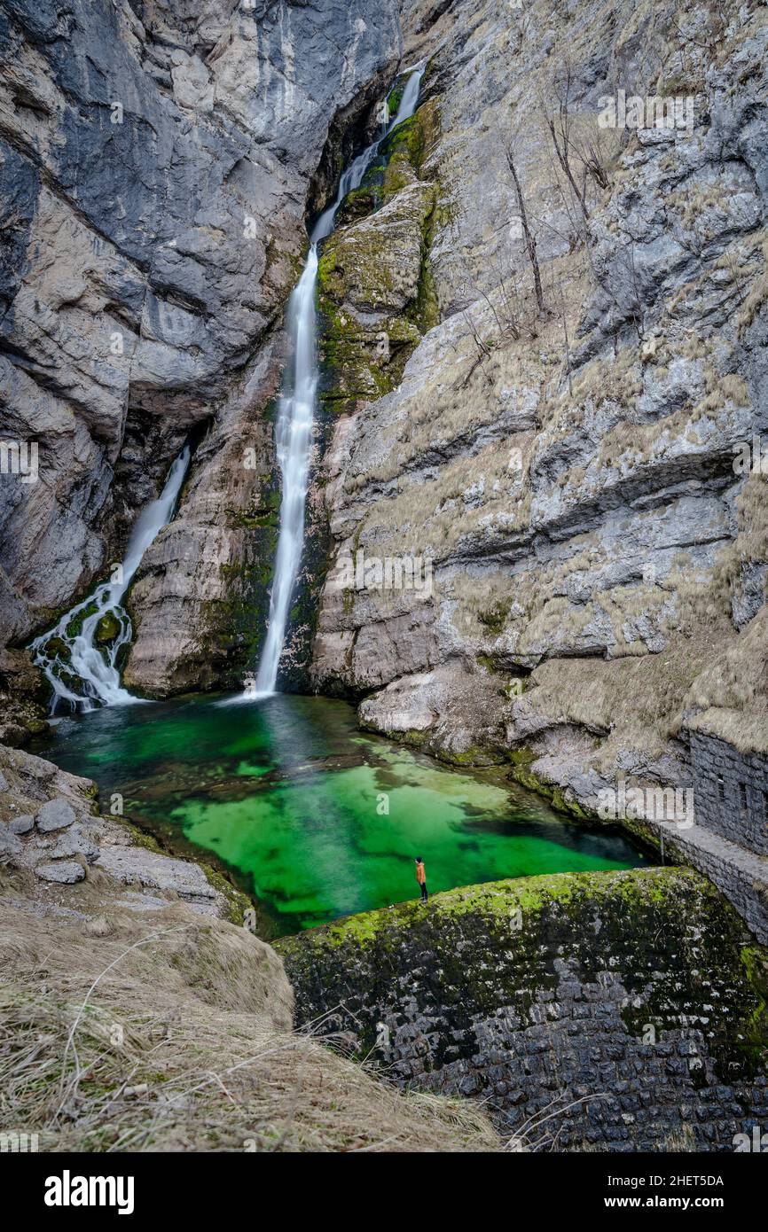 Successo - una persona in piedi sul bordo della cascata Savica in Slovenia, lago di Bohinj, Parco Nazionale del Triglav Foto Stock
