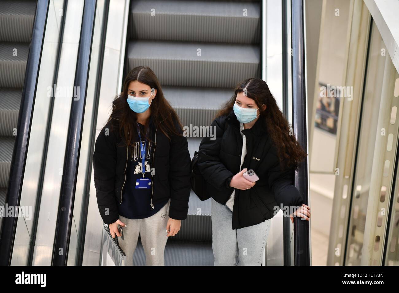 Giovani ragazze donne che indossano maschere facciali nel centro commerciale britannico durante Covid Pandemic Britain, UK, 2021 Foto Stock