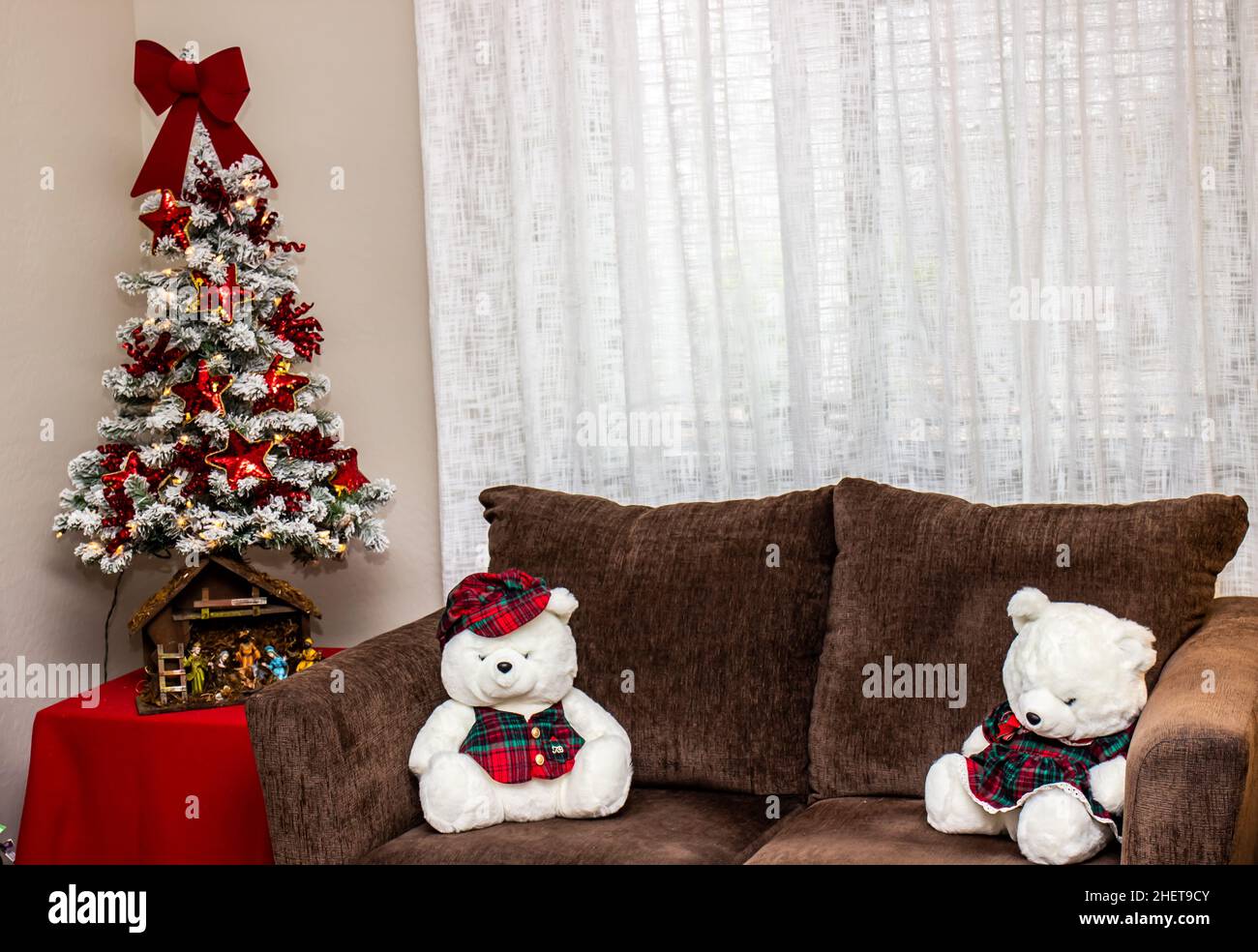 Due orsi bianchi seduti sul sedile d'amore accanto al piccolo albero di Natale Foto Stock