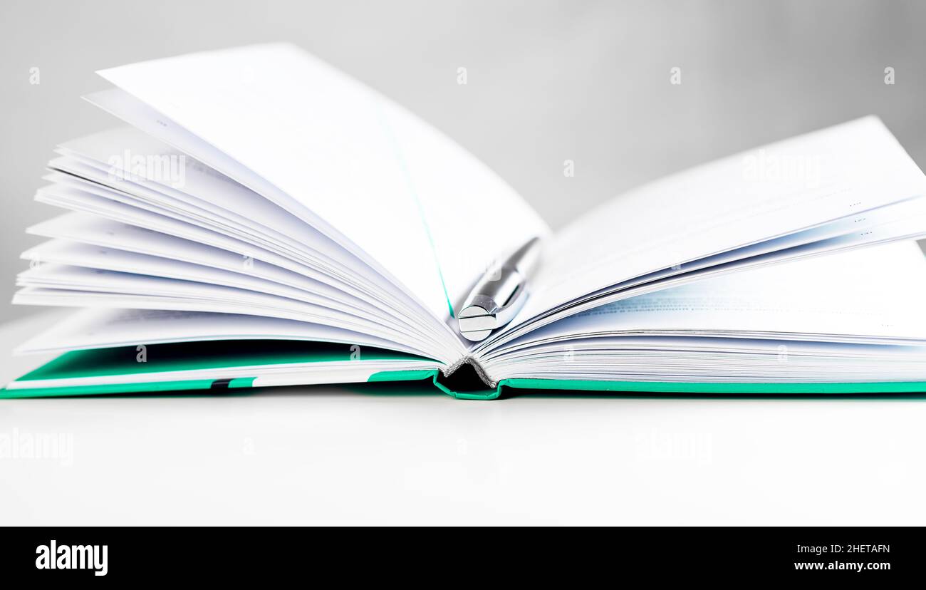 Aprire il libro con le pagine e la penna argentata. Concetto di conoscenza. Foto Stock
