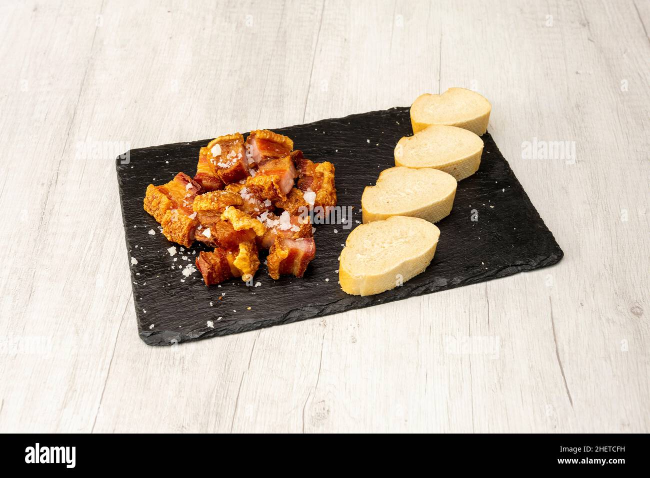 Un torrezno è una striscia di pancetta, sempre con la sua pelle, fritta o saltata in padella o tostata su una griglia. Di solito i torreznos sono croccanti e dorati Foto Stock