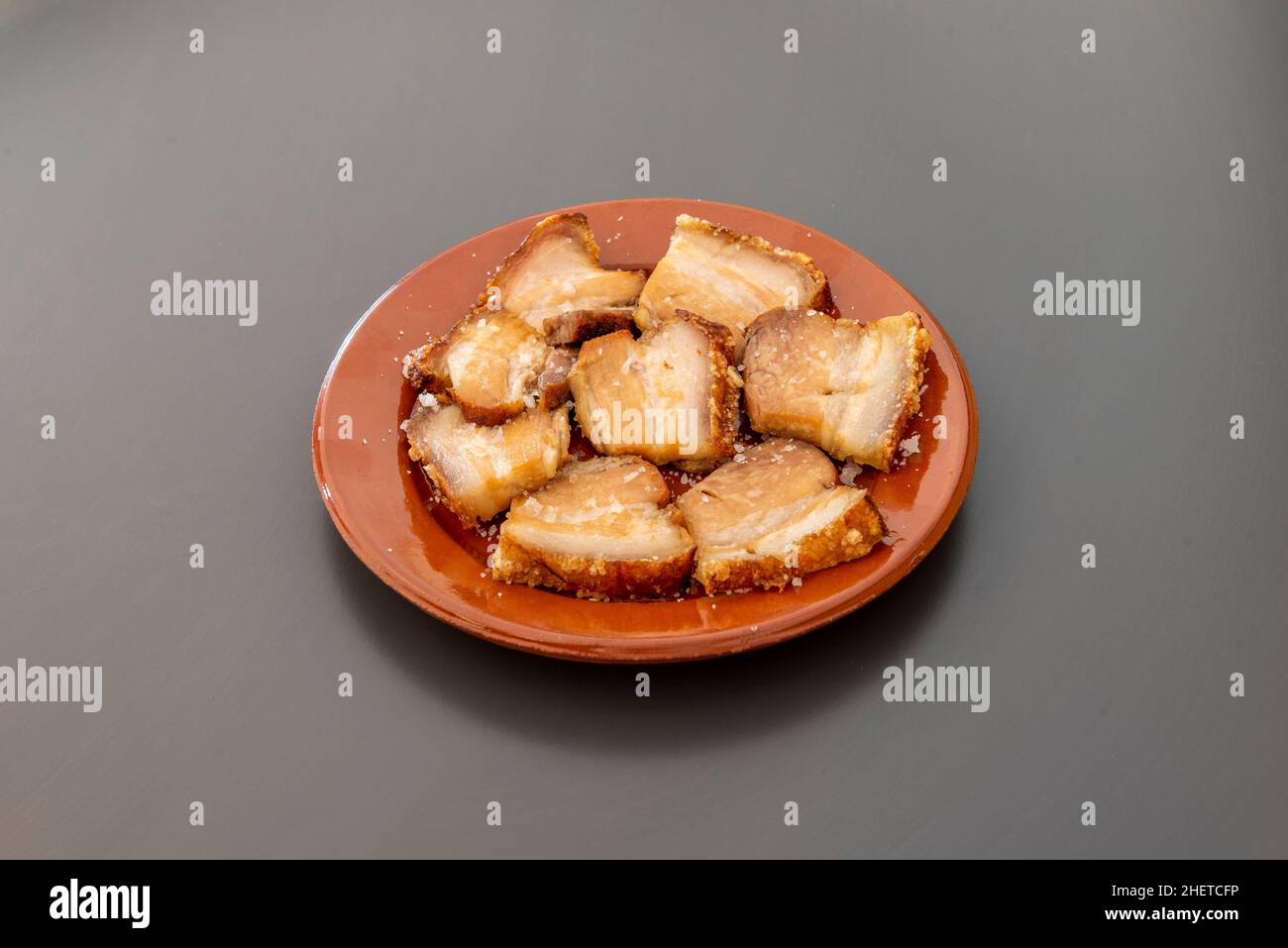 Un torrezno è una striscia di pancetta, sempre con la sua pelle, fritta o saltata in padella o tostata su una griglia. Di solito i torreznos sono croccanti e dorati Foto Stock