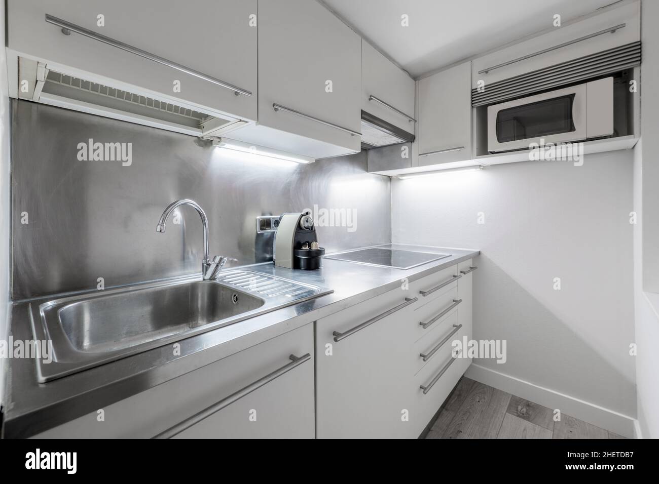Piccola cucina con piano di lavoro in acciaio inox in appartamento affitto per le vacanze Foto Stock