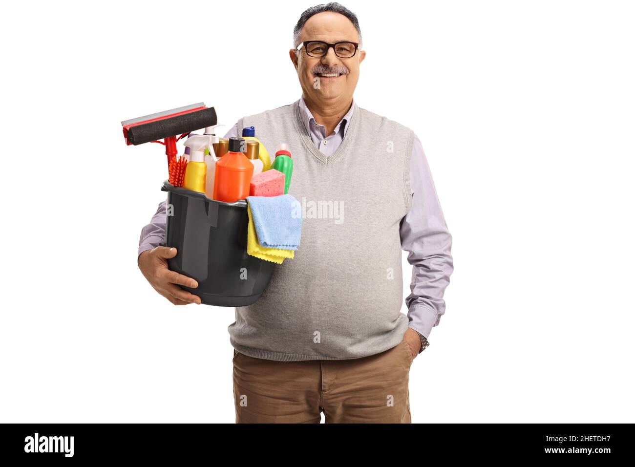 Uomo casual maturo che tiene un secchio con forniture di pulizia e sorridente isolato su sfondo bianco Foto Stock