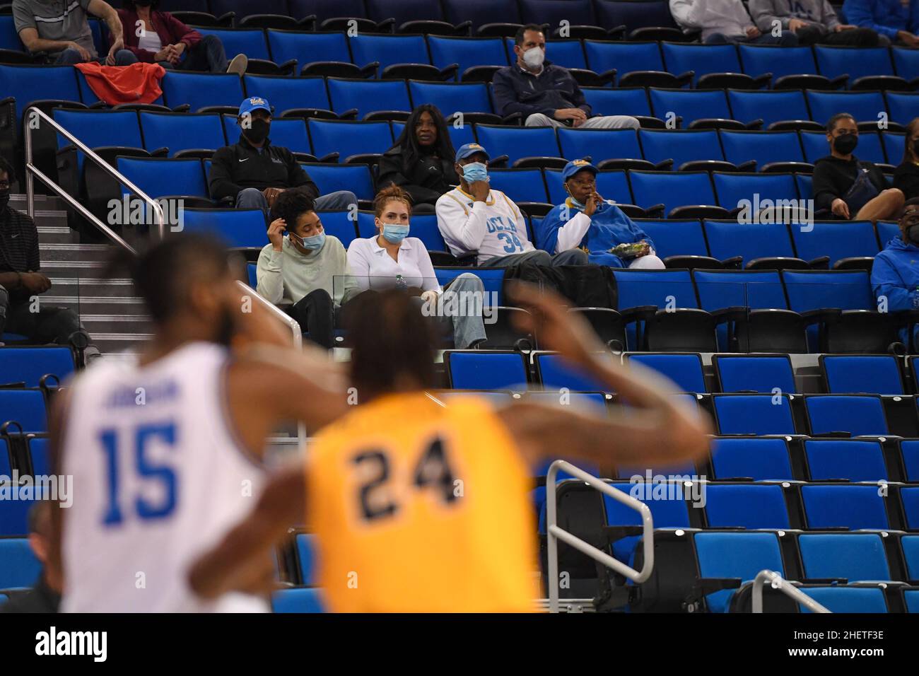 I fan indossano coperture facciali in mezzo al COVID-19 Omicron variante epidemia durante una partita di pallacanestro NCAA tra UCLA Bruins e Long Beach state Foto Stock