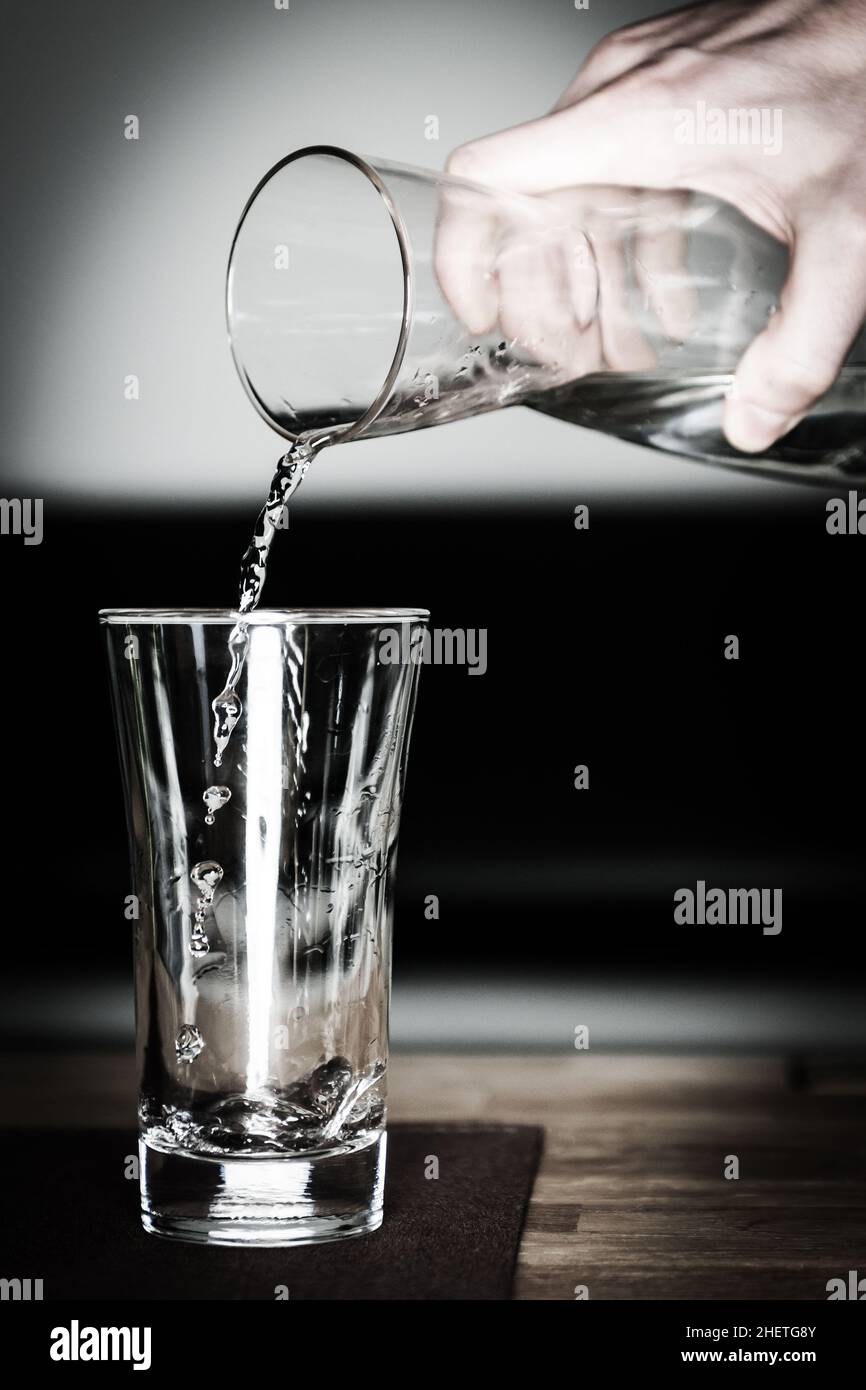 versate dell'acqua pulita fresca nel bicchiere con la caraffa Foto Stock versate dell'acqua pulita fresca nel bicchiere con la caraffa Foto Stock